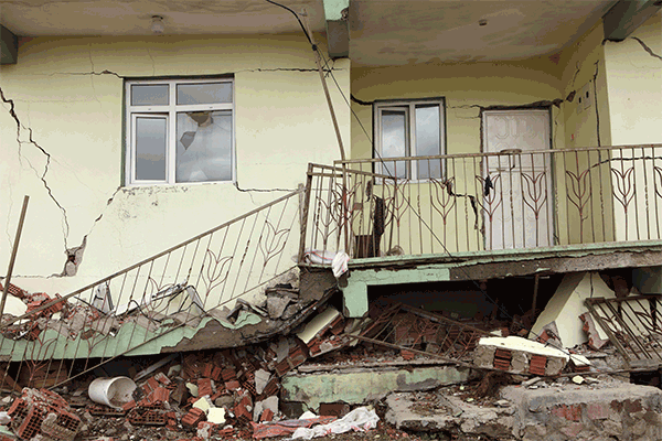 Image: Earthquake damage to front of raised house including porch