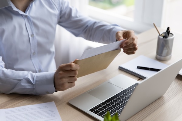 Person reviewing letter near laptop image
